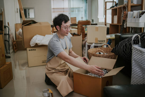 istock Man prepping things for donations at dirty home 1366798425