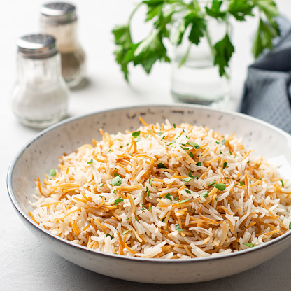 Rice with vermicelli in plate on concrete background. Traditional arabic dish. Selective focus.