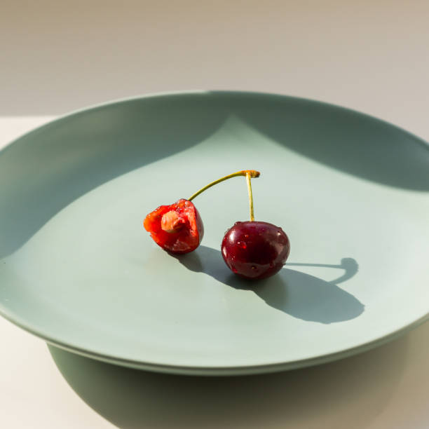 One red strawberry on the green plate. Healthy lifestyle concept.