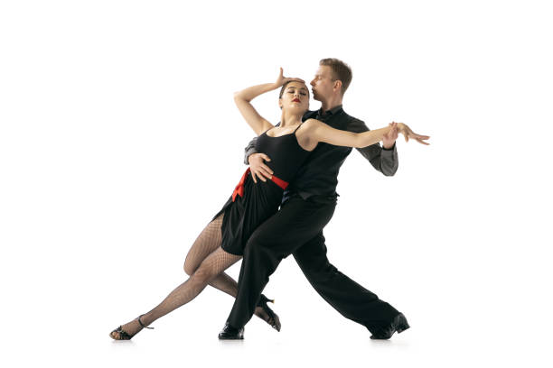 istock Flexible young couple dancing Argentine tango isolated on white studio background. Artists in black stage costumes 1366800026