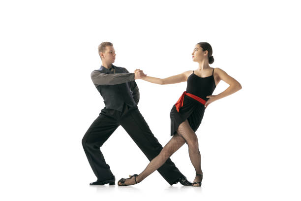 istock Flexible young couple dancing Argentine tango isolated on white studio background. Artists in black stage costumes 1366800060