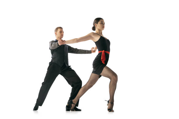 istock Dynamic portrait of flexible young dancers dancing Argentine tango isolated on white studio background. Artists in black stage costumes 1366800062