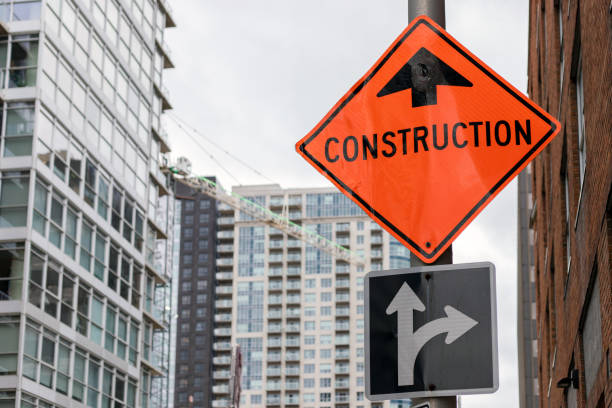 istock Construction orange sign near construction site against buildings 1366807762