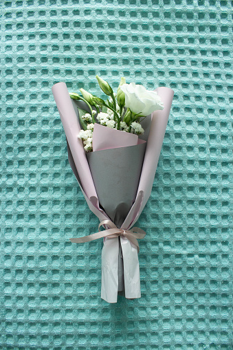 A bouquet of flowers on a turquoise background. Mother's Day. International Women's Day. The concept of the holiday.