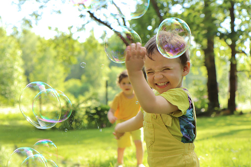 Small children play with soap bubbles.