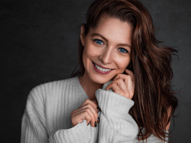 Smiling blue eyed 40 years old woman looking at camera - psychology and feminine health concept stock photo