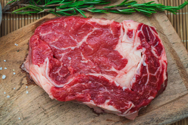 rohes ribeye-steak auf einem hölzernen schneidebrett. lebensmittelkonzept. luftbild. - steak argentina food silverware stock-fotos und bilder