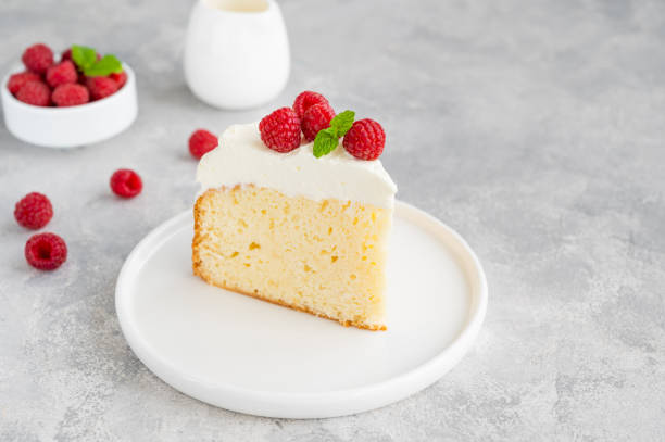 gâteau tres leches avec crème fouettée et framboises fraîches sur un fond de béton gris. gâteau traditionnel d’amérique latine. espace de copie. - part de gâteau photos et images de collection