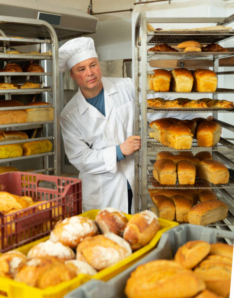 istock Bakery worker pushing trolley with baked loaves 1366814169