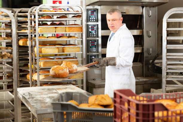 istock Baker takes out hot bread from the oven 1366814199