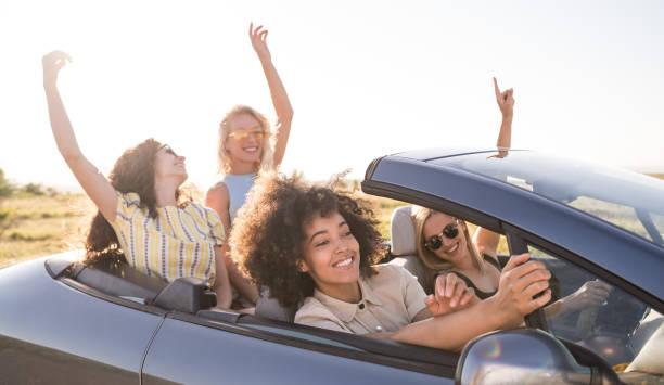 istock Girlfriends having fun on road trip with car 1366814280