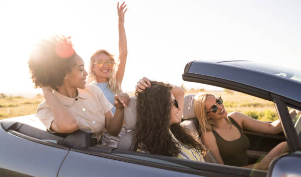 istock Girlfriends having fun on road trip with car 1366814282