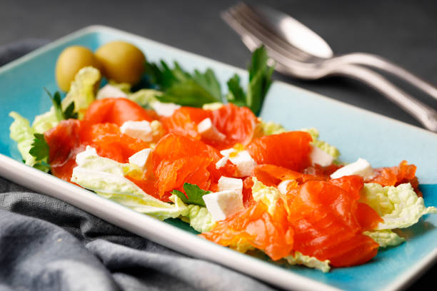 istock Gourmet food - salad from red salmon and herbs on a rectangular plate. 1366815264