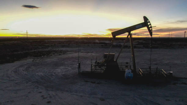 drone view of oil or gas drill fracking rig pad as the sun rises in new mexico - oil industry industry new mexico oil drill imagens e fotografias de stock