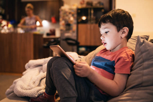 istock Little boy using tablet and gaming at home during isolation 1366817527