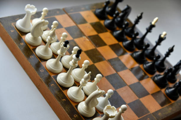 istock An old chessboard with white and black pieces 1366819773