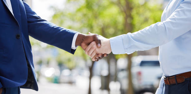 istock Shot of two unrecognizable businesspeople sharing a handshake outside 1366820932