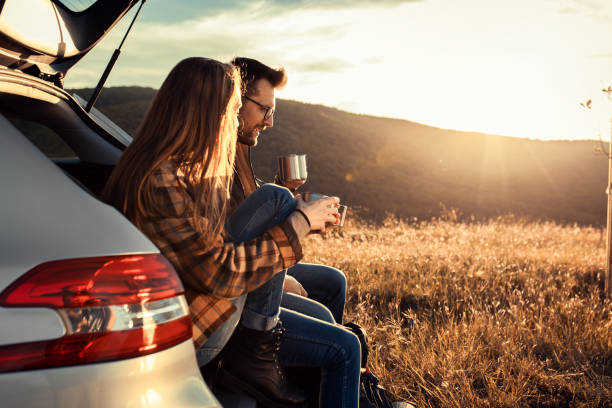 휴식을 취하고 커피를 마시는 자동차 트렁크에 앉아 도로 여행을 하는 커플. - car mount 뉴스 사진 이미지