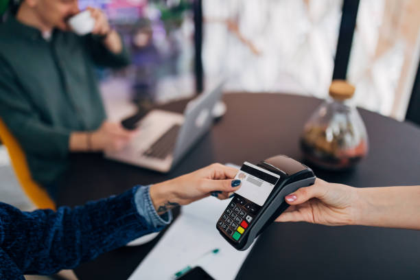 primer plano de pago de una factura de café con una tarjeta de crédito en una cafetería. concepto de finanzas, pagos, cash free y personas. - mobile phone coffee shop group of people women fotografías e imágenes de stock