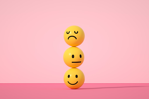 Emoji con cara sonriente, triste y neutra sobre fondo de color rosa photo