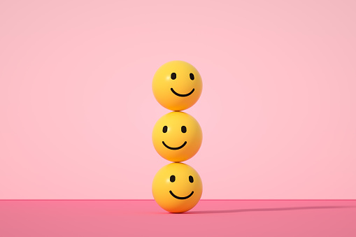 Emoji con cara sonriente sobre fondo rosa photo