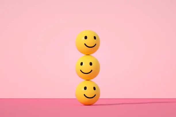 Photo of Emoji with smiley face on pink background