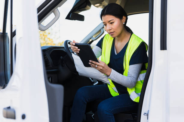 istock In driver's seat, mail person uses app to confirm address 1366824788