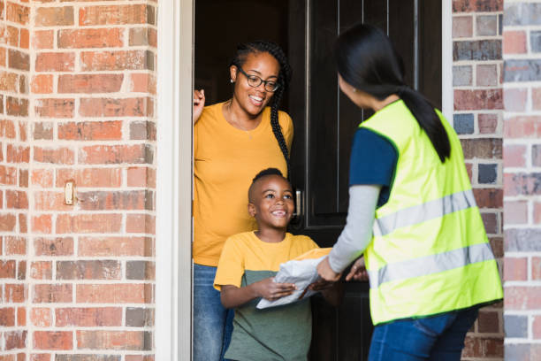 istock Elementary age boy happily receives packages from mail person 1366824798