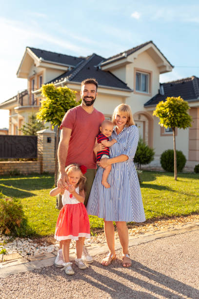 rodzice i dzieci stojący przed swoim nowym domem - happiness family outdoors house zdjęcia i obrazy z banku zdjęć