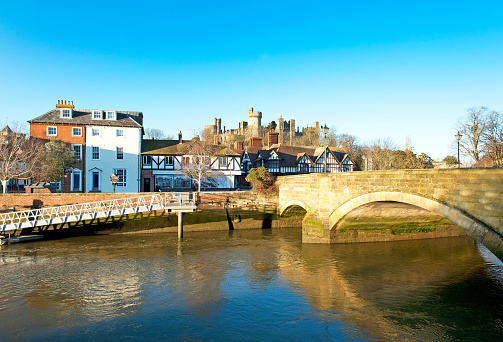 Arundel, West Sussex, England. Arundel is an ancient market town built at a bridge point over the River Arun, with a skyline dominated by the huge Arundel Castle - built by the Normans - and the Gothic revival architecture of Arundel Cathedral which overlooks the meadows and grasses of the fertile South Downs