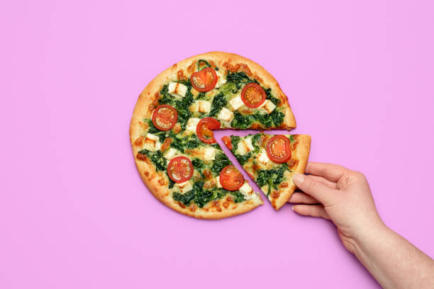 donna mano prendendo una fetta di pizza. pizza vegetariana fatta in casa con spinaci e formaggio feta - color image copy space high angle view isolated foto e immagini stock