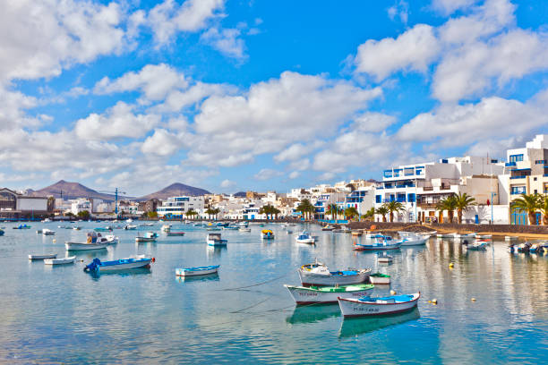 Arrecive, Spain - December 23, 2010: fisherman anchors the boat in Charco de San Gines in Arrecife, Spain. The harbor area was remodelled by Canarian architect César Manrique in 1984.