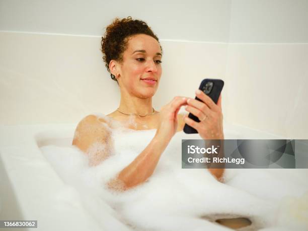 Woman Enjoying A Bubble Bath Stock Photo - Download Image Now - Mobile Phone, Taking a Bath, Bathroom