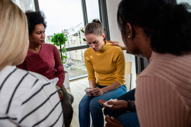 istock Diverse group of people sitting in circle in group therapy session. 1366830471