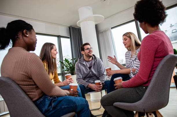 istock Diverse group of people sitting in circle in group therapy session. 1366831720