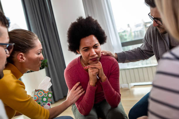 istock Diverse group of people sitting in circle in group therapy session. 1366831734