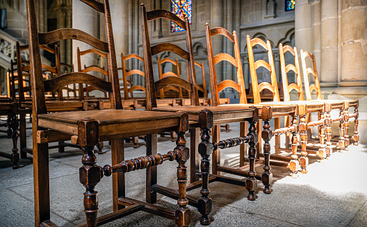 Row of vacant wooden chairs in a cathedral
