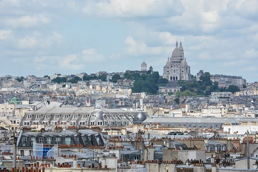 Paris skyline with Montmartre hill and Sacre Coeur Basilica viewed from Buttes-Chaumont Park.