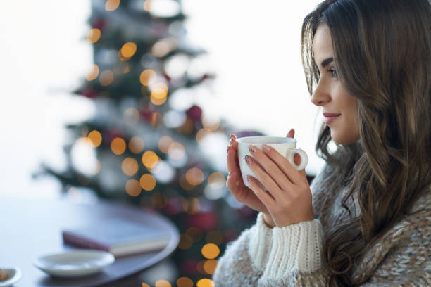 Charming woman drinking coffee while resting at home
