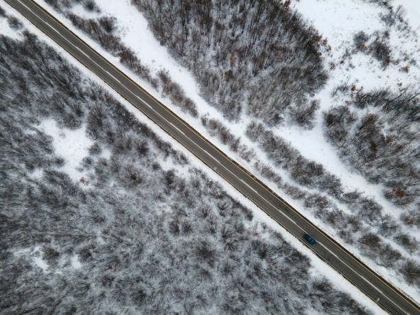 High angle top down aerial view drone image on road trough the trees and forest in mountain range covered with white snow in winter day near Knjazevac in Serbia car Travel journey and vacation concept imagen de dron de vista aérea de arriba hacia abajo de alto ángulo en la carretera a través de los árboles y el bosque en la cordillera cubierta de nieve blanca en el día de invierno cerca de knjazevac en serbia automóvil viaje de viaje y concepto de
