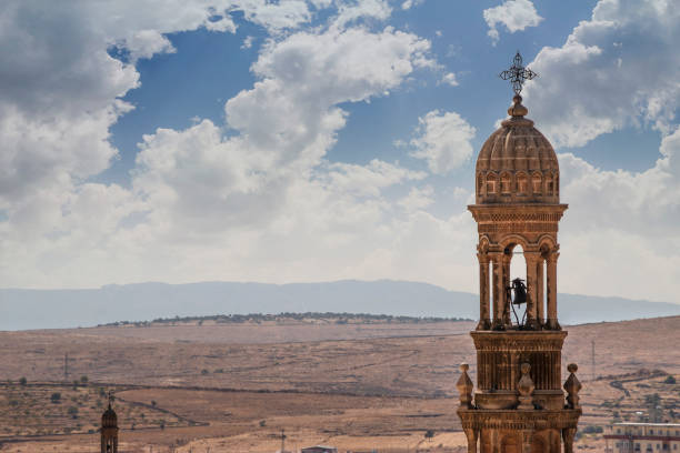 glockenturm der kirche auf dem hintergrund des tals midyat türkei - midyat stock-fotos und bilder