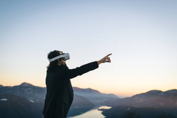 istock Businessman wears VR glasses on mountain ridge 1366837427