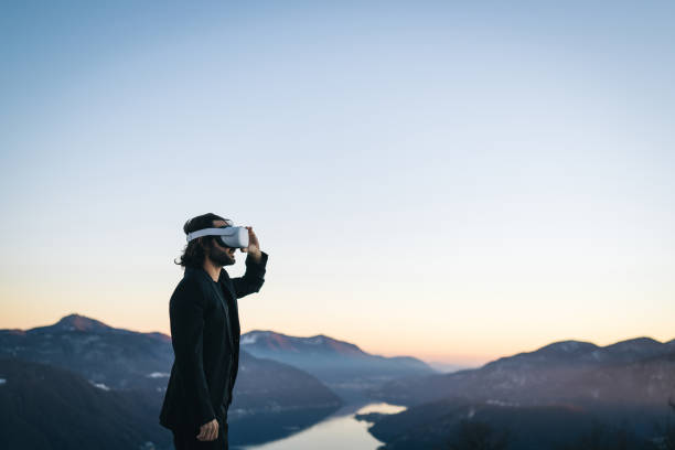 istock Businessman wears VR glasses on mountain ridge 1366837429