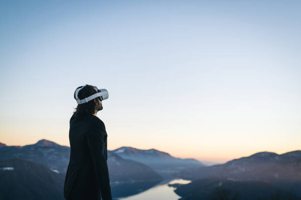 istock Businessman wears VR glasses on mountain ridge 1366837430