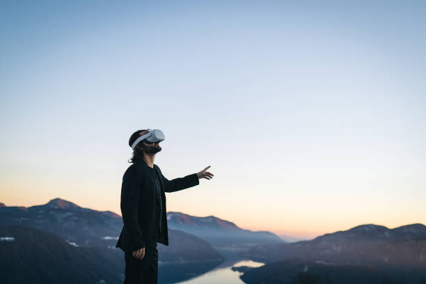 istock Businessman wears VR glasses on mountain ridge 1366837440