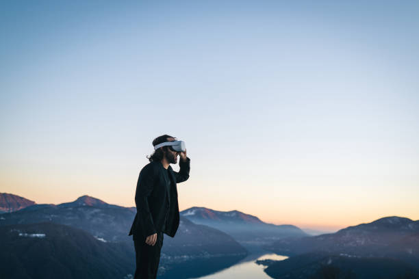 istock Businessman wears VR glasses on mountain ridge 1366837597