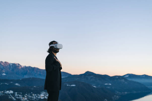 istock Businessman wears VR glasses on mountain ridge 1366837692