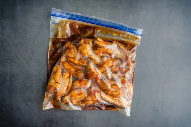Photo of Raw Chicken Wings Marinating in a Plastic Bag