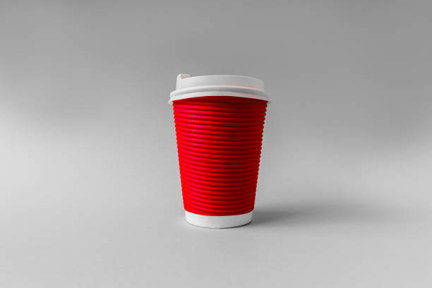 istock Disposable red paper cup for coffee on a gray background. 1366844440
