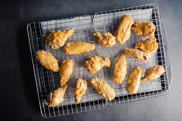 Raw chicken wings arranged on a wire rack on a sheet pan